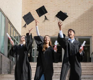 Group of graduates throwing their caps into the air to celebrate academic achievement and educational success.