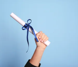 Hand holding a diploma, symbolizing academic achievement, educational milestones, and student success.